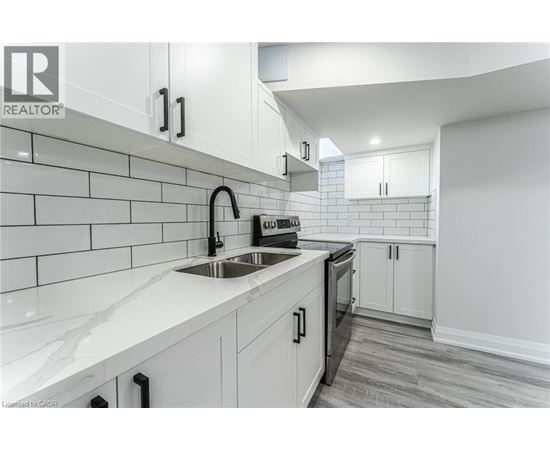 A modern kitchen with white cabinets and a marble countertop.