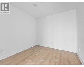 A room with wooden flooring and white walls.