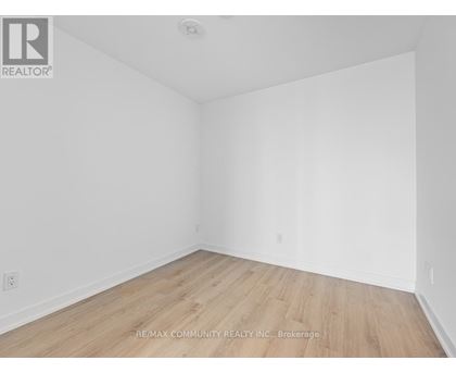 A room with wooden flooring and white walls.
