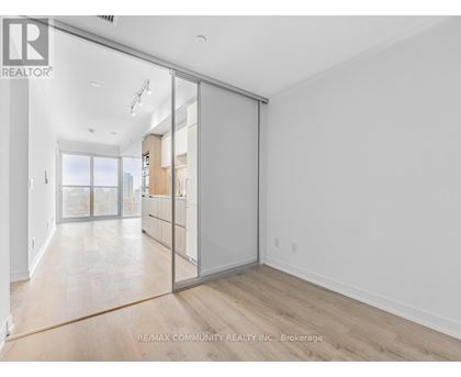 A room with a sliding glass door leading to a balcony.