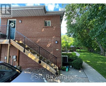 A brick house with a black gate and a car parked in front.