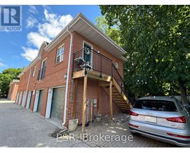 A silver Audi is parked in front of a red brick house.