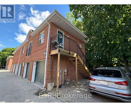 A silver Audi is parked in front of a red brick house.
