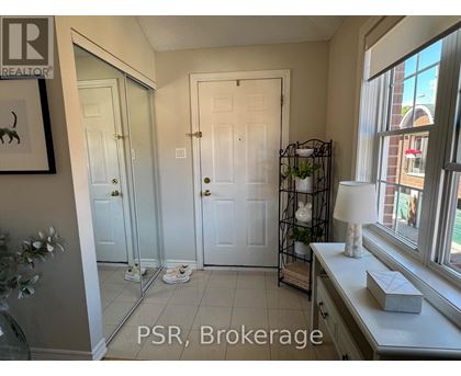 A bathroom with a mirror, sink, and a plant on the windowsill.