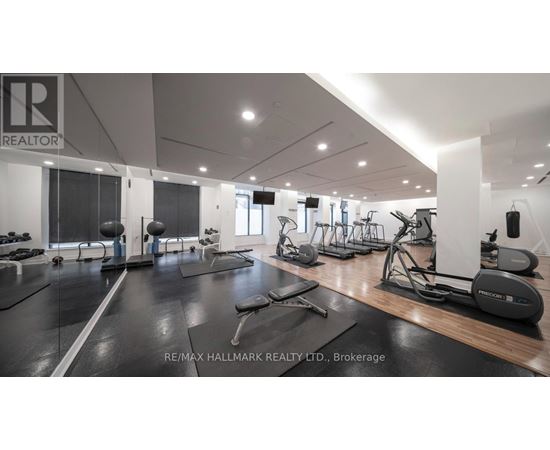 A gym with a variety of equipment including treadmills, weights, and exercise machines.