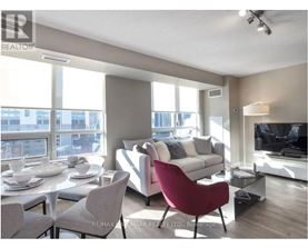 A living room with a red chair and a white couch.