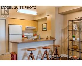 A model suite photo of a kitchen with a bar stool.