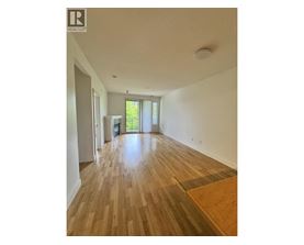 A room with wooden flooring and a window with blinds.