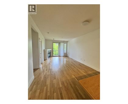 A room with wooden flooring and a window with blinds.