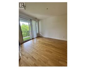 A room with wooden flooring and sliding glass doors.