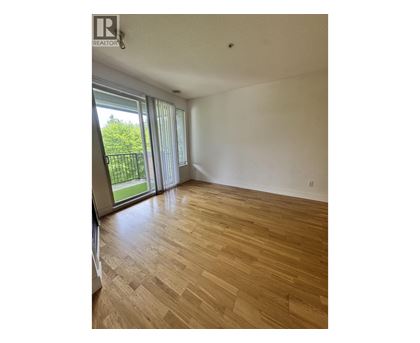 A room with wooden flooring and sliding glass doors.