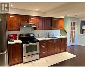 A kitchen with wooden cabinets and a black stove top oven.