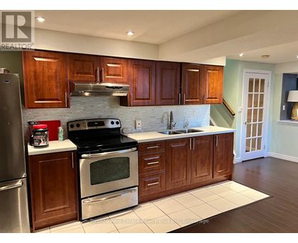 A kitchen with wooden cabinets and a black stove top oven.