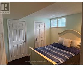 A bedroom with a bed, two doors, and a window.