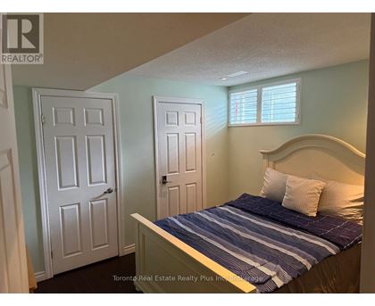A bedroom with a bed, two doors, and a window.