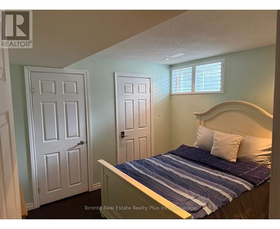 A bedroom with a bed, two doors, and a window.