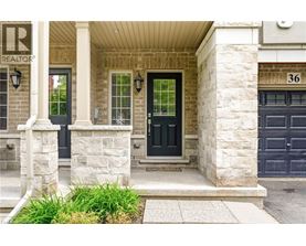 A house with a black door and a stone pillar in front.