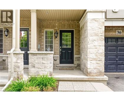 A house with a black door and a stone pillar in front.