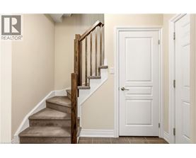 A wooden staircase with a white door in a room.