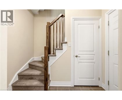 A wooden staircase with a white door in a room.
