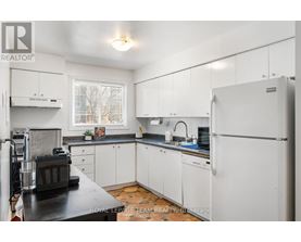 A kitchen with white cabinets and a black countertop.