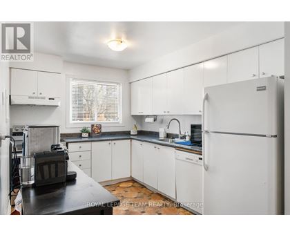 A kitchen with white cabinets and a black countertop.