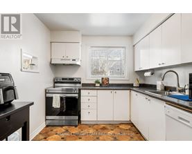A kitchen with white cabinets and a black countertop.