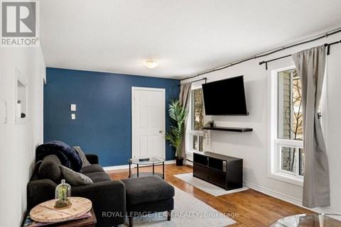 A living room with a black couch and a wooden coffee table.