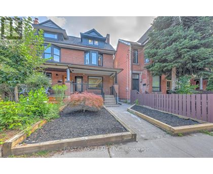 A red brick house with a garden in front.