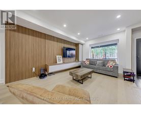 A living room with a flat screen TV and a grey couch.