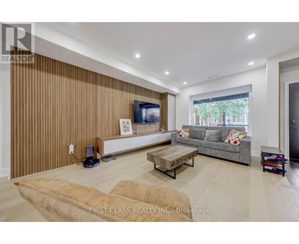 A living room with a flat screen TV and a grey couch.
