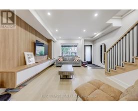 A spacious living room with a staircase on the right side.