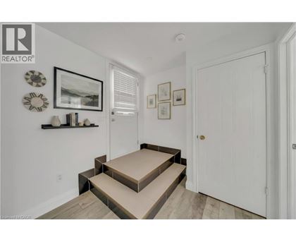 A hallway with a white door and a wall with pictures and decorations.