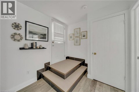 A hallway with a white door and a wall with pictures and decorations.