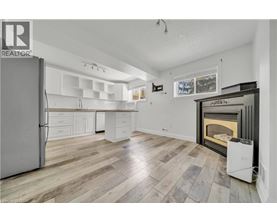 A spacious kitchen with a refrigerator, cabinets, and a fireplace.