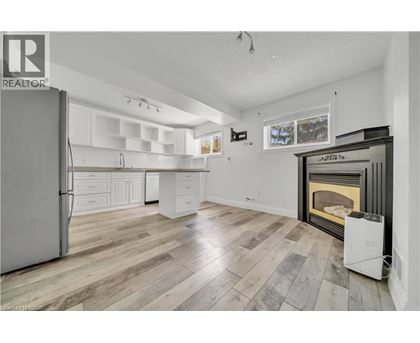A spacious kitchen with a refrigerator, cabinets, and a fireplace.