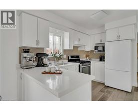 A white kitchen with a wooden tray on the counter.