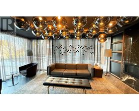 A modern living room with a large sofa and a chandelier.