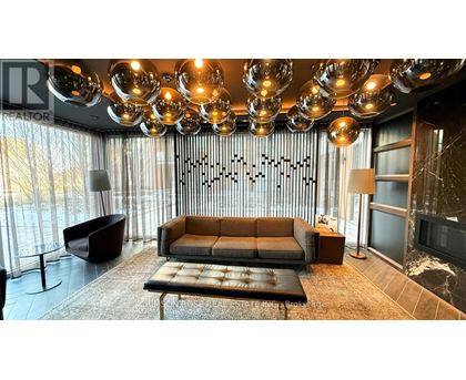 A modern living room with a large sofa and a chandelier.