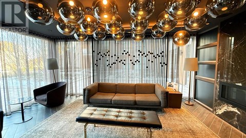 A modern living room with a large sofa and a chandelier.
