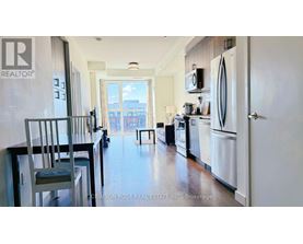 A kitchen with a white refrigerator and a dining table with chairs.