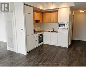 A kitchen with white cabinets and a microwave built into the counter.