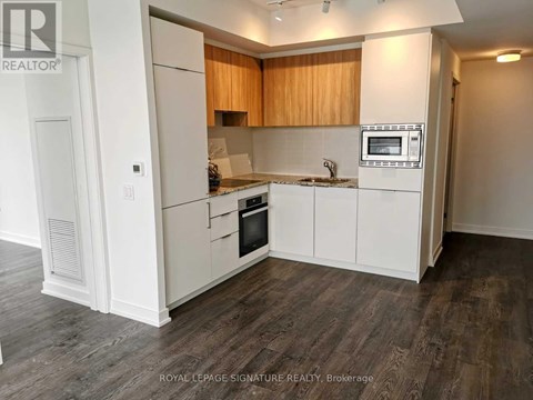 A kitchen with white cabinets and a microwave built into the counter.