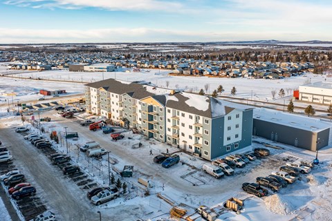 A parking lot with cars and a building in the background.