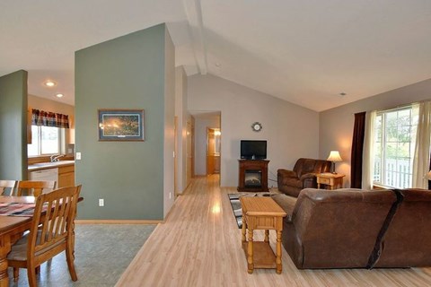A living room with a brown couch and a wooden table.