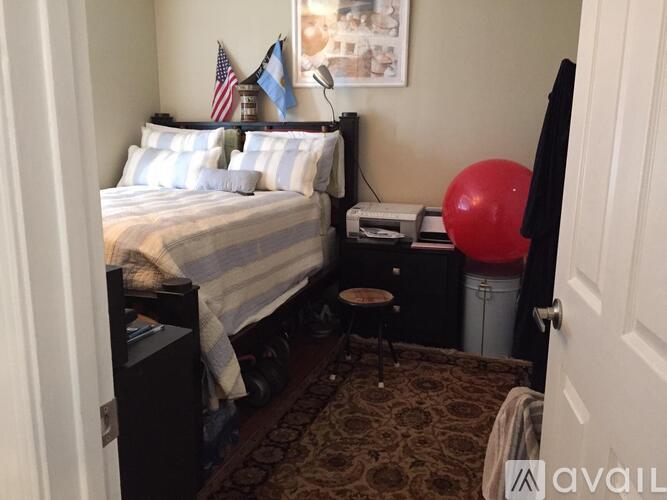A bedroom with a bed, a red balloon, and a picture on the wall.