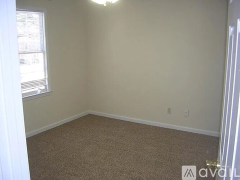 A room with a carpeted floor and a window.