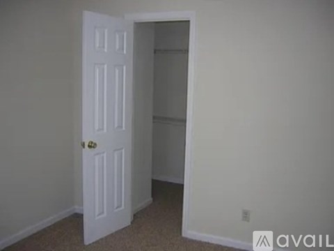 A white door is open to a small empty room.