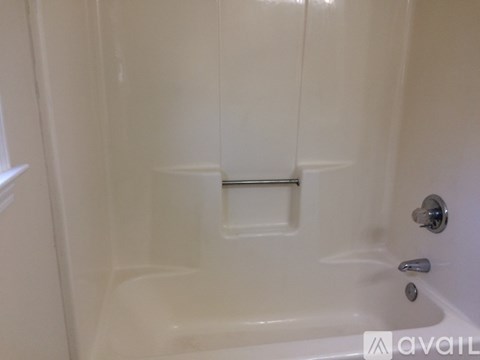 A white bathtub with a silver faucet and a silver handle.