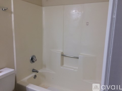 A white bathroom with a tub and toilet.